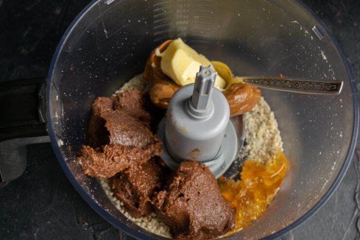 Adding butter and condensed milk Adding butter and dulce de leche into the blender bowl.