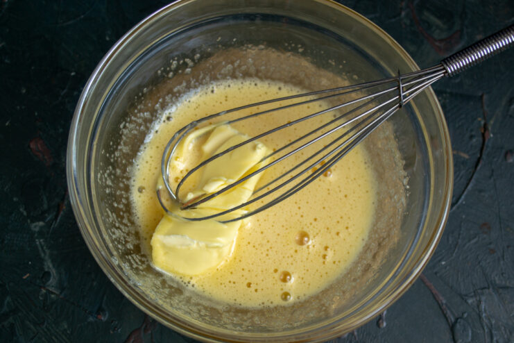Whisking soft butter into the egg and sugar mixture