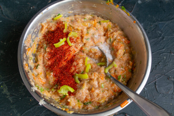 Sprinkling spices and paprika into the ground fish mixture