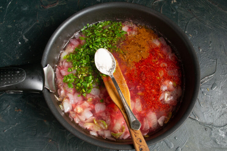 Adding salt, sugar, paprika, and fresh chopped herbs to the strained redcurrant sauce