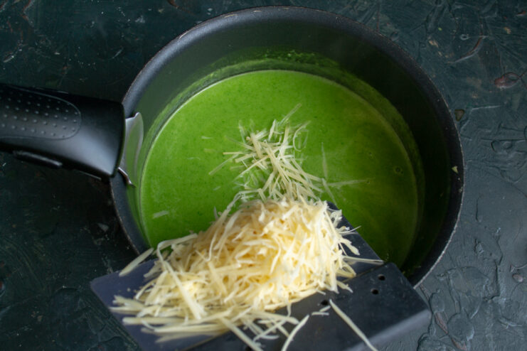 Stirring Parmesan cheese into the creamy soup