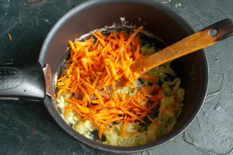 Stirring in carrots Adding coarsely grated carrots to the onion and flour mixture