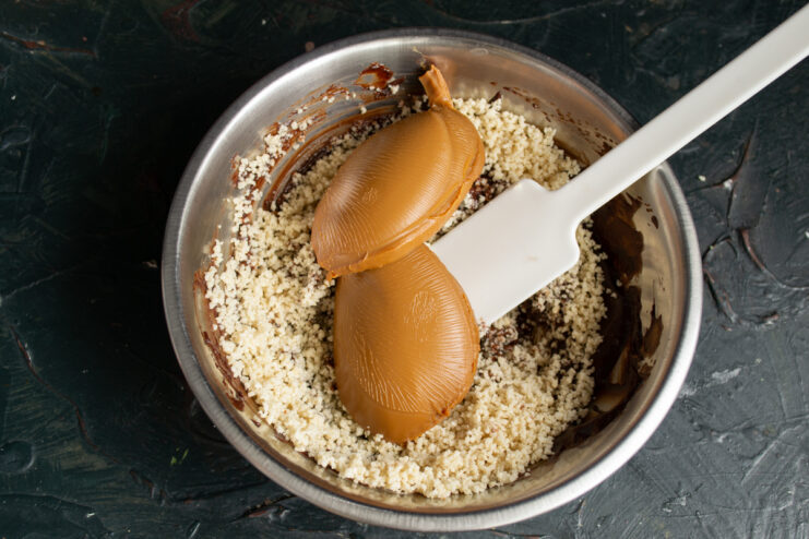 Adding caramelized condensed milk Mixing thick caramelized condensed milk into the chocolate peanut base