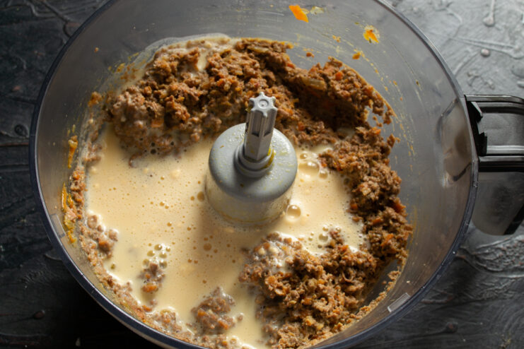 Mixing the pate base Adding the egg and cream binder into the liver base in a food processor.