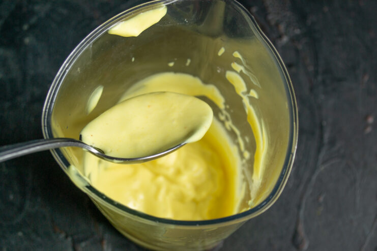 Whisking the homemade mayonnaise Thick and glossy homemade mayonnaise in a blender cup