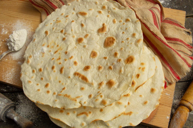 Stack of fresh thin homemade lavash on a wooden board
