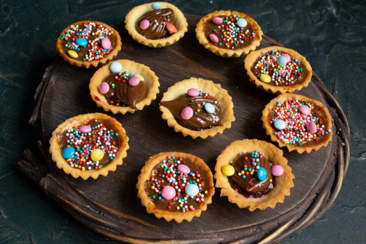 Finished shortcrust pastry tartlets Final presentation of shortcrust tartlets with chocolate cream on a wooden board