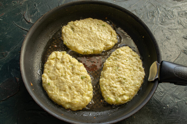 Frying The Schnitzels Shaping oval cauliflower schnitzels with a spatula in a hot skillet