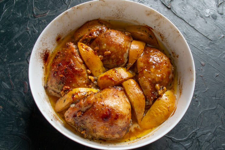Finished Dish In The Pan Golden brown roasted chicken with quince in a baking dish