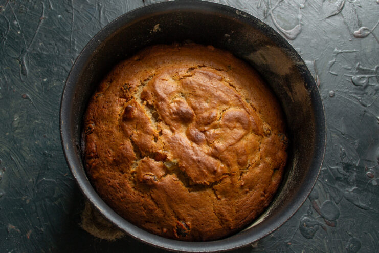 Freshly baked golden-brown cake sitting inside a baking pan