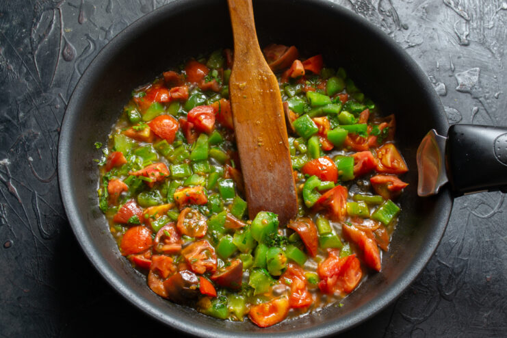 Softened cooked vegetables in a skillet ready for the egg mixture