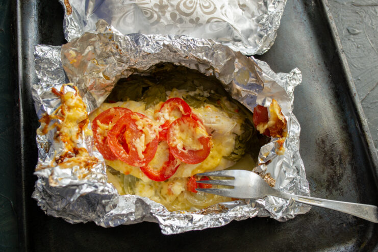 Baked result Opened foil packet revealing melted cheese and cooked chicken