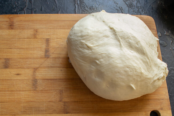 Turning out the proofed dough Transferring the fully proofed, fluffy yeast dough onto a lightly floured board