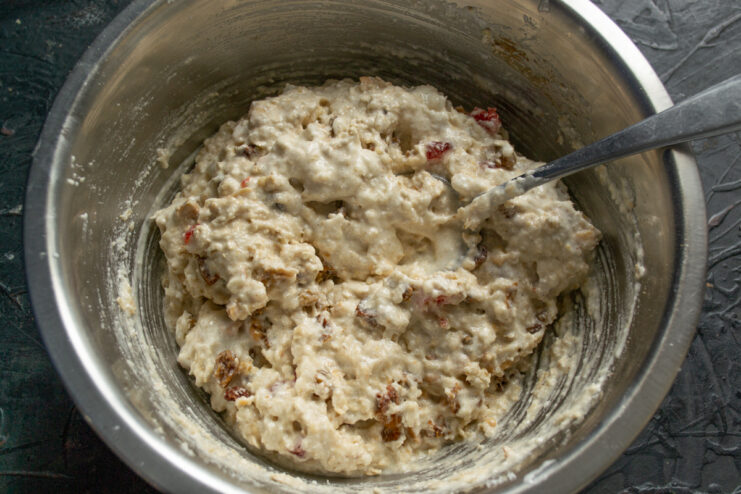 Finished chunky dough Thick mixed cookie dough with visible fruits in a metal bowl