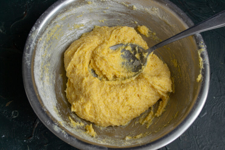 Dough consistency Thick and sticky polenta cookie dough resting in a metal bowl.