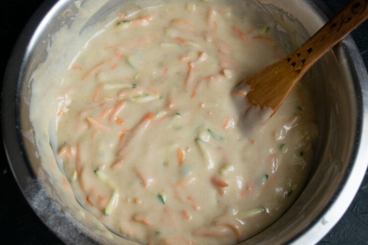 Cake batter resting in a bowl with a wooden spatula
