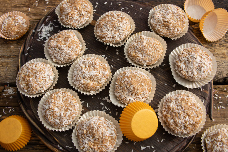 Finished homemade peanut and almond candies coated in shredded coconut.