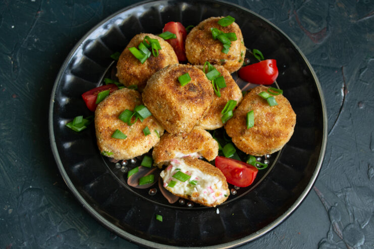 Serving the finished dish Sliced warm crab croquettes served on a plate