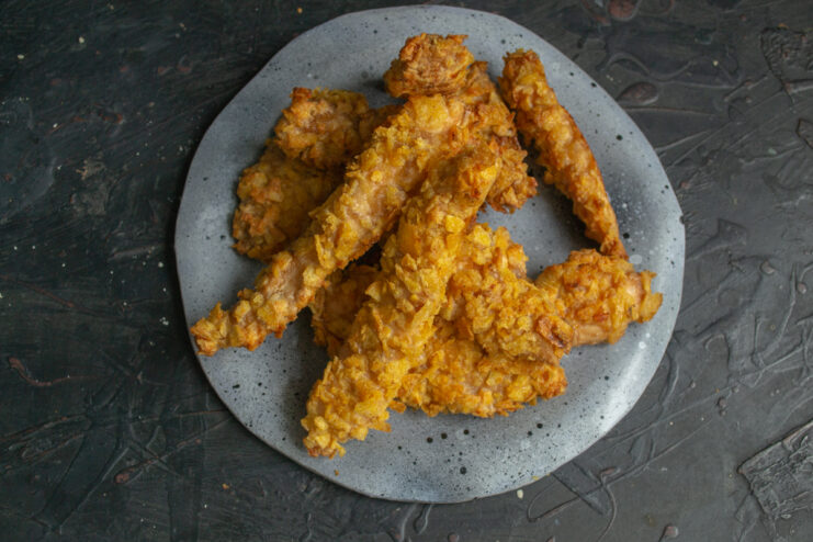 Serving the hot chicken strips Plated crunchy chicken strips served hot on a grey dish