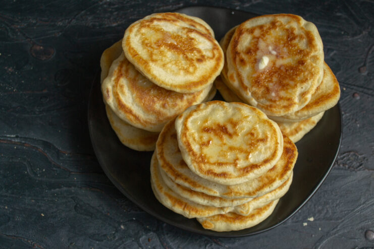 Serving the pancakes Finished pancakes with butter on a dark background