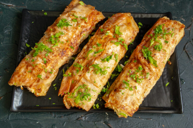 Hot crispy lahmacun rolls garnished with fresh parsley and cilantro