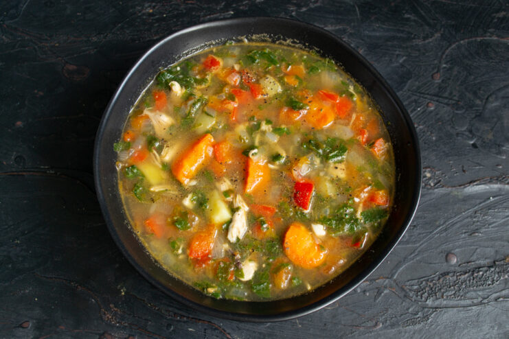 Serving The Soup Finished nettle soup presented in a deep black bowl