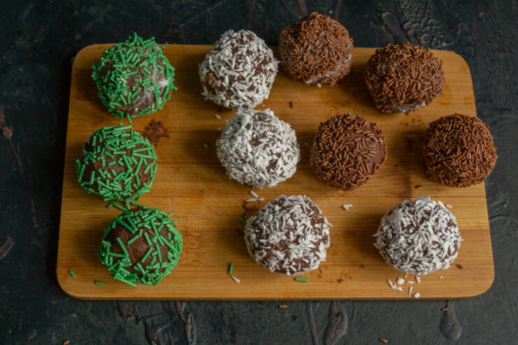 Finished chocolate petits fours with various coatings on a board.