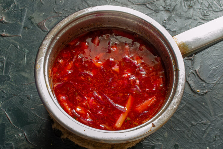 Resting the Cooked Soup A covered pot of freshly cooked borscht wrapped in a towel to steep.