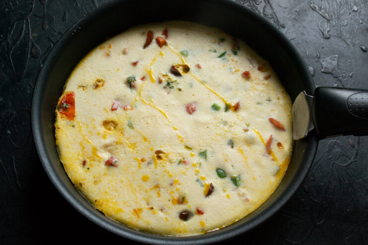 Cooked omelet covered with a lid in a skillet
