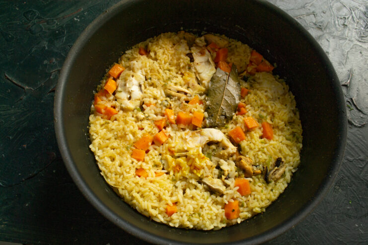 Resting the plov under a lid Finished plov resting in a skillet under a lid and towel