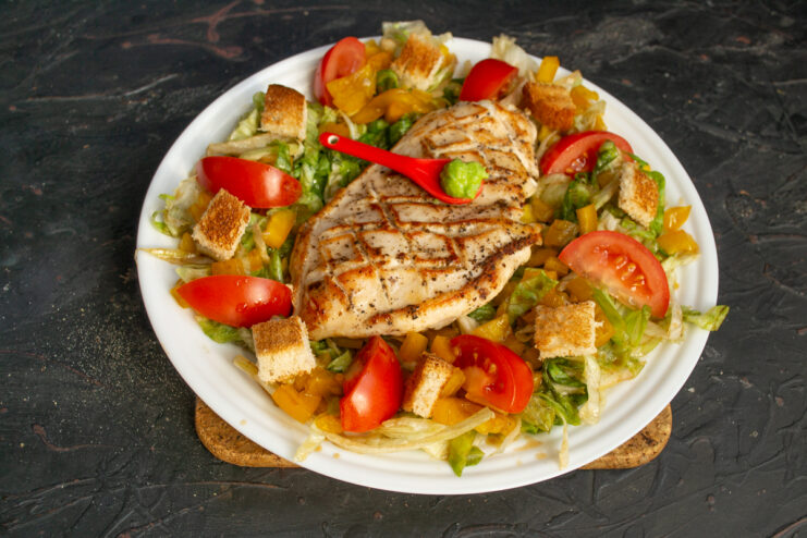 Final touches Finished chicken salad garnished with croutons and a dollop of wasabi
