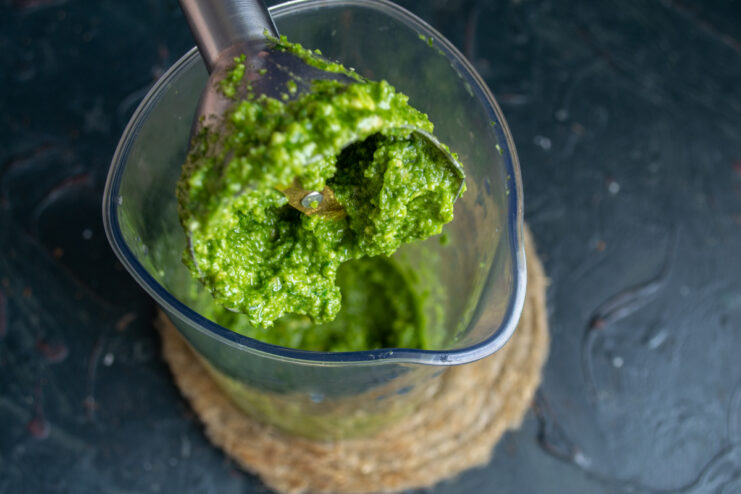 Blending the pesto Freshly blended thick green pesto sauce on an immersion blender attachment