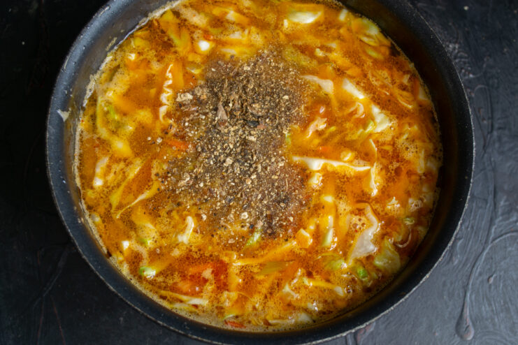 The Secret Ingredient: Mushroom Powder Dried mushroom powder being added into the simmering broth.