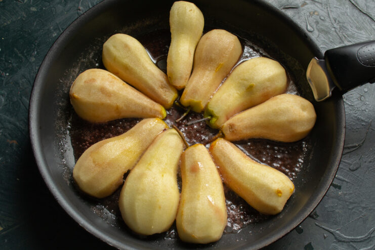 Simmering Pears Halved pears simmering in bubbling caramel inside a skillet