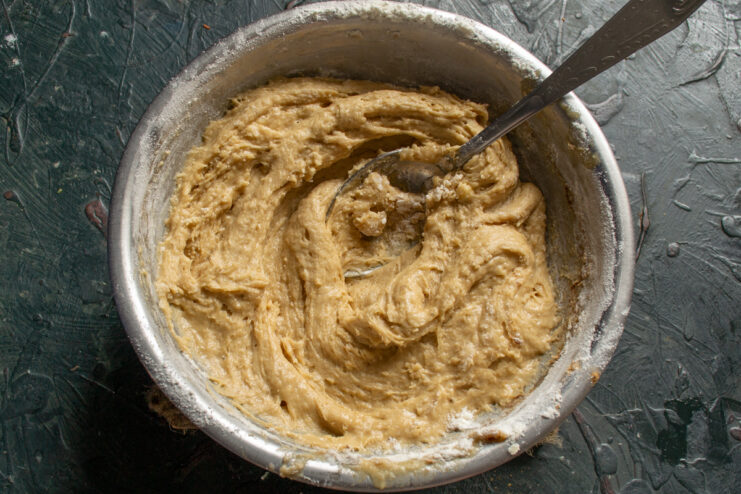 Thick and sticky gingerbread dough resting in a mixing bowl
