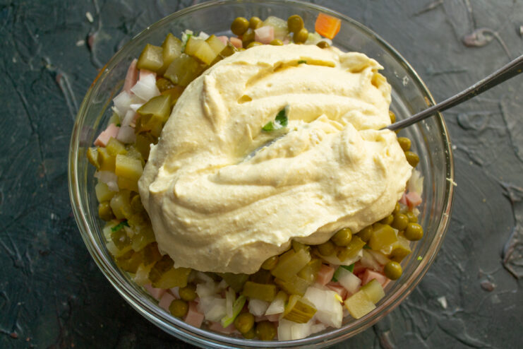 Dressing the salad Thick homemade dressing poured over the salad ingredients