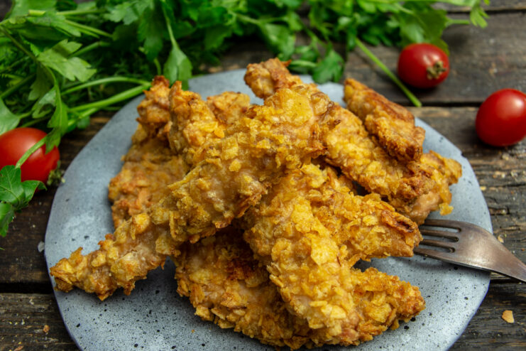 Golden and crunchy oven-baked chicken strips on a plate