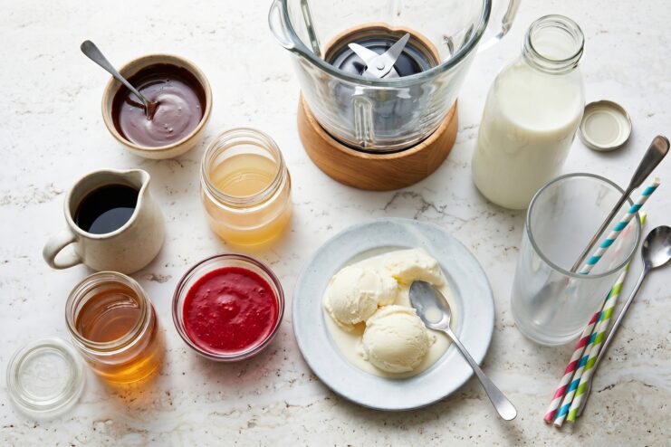 Prepared Ingredients for Milkshakes Prepared milkshake ingredients including cold milk, ice cream scoops, coffee concentrate, and fruit syrups.
