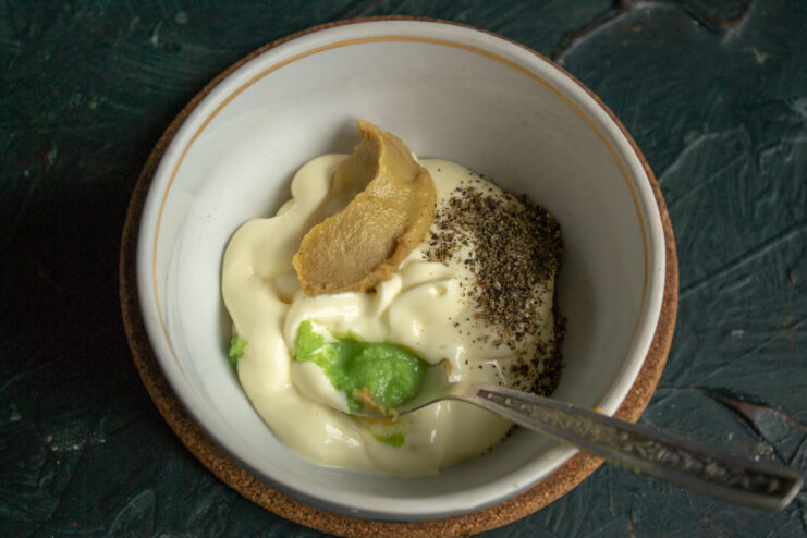 Preparing the zesty dressing Ingredients for vegan salad dressing including mayonnaise, mustard, and wasabi