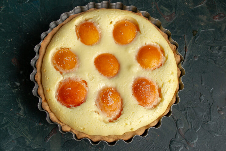 Baked tart in the pan Freshly baked tart with a golden crust in a fluted metal pan
