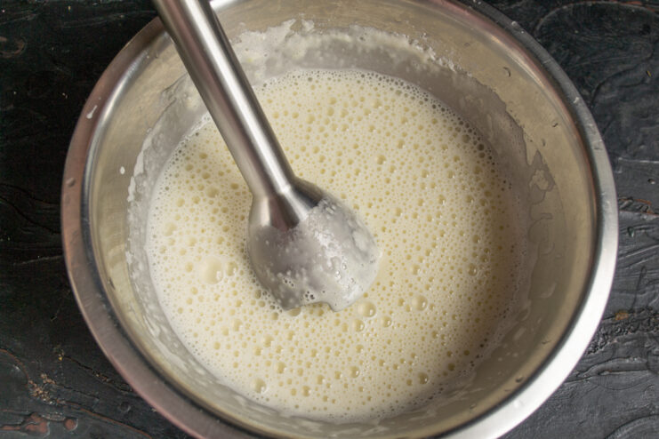 Puréeing crepe batter with an immersion blender in a bowl