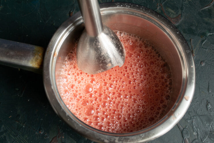 Blending tomatoes into a smooth juice Blending chopped tomatoes in a saucepan using a hand immersion blender