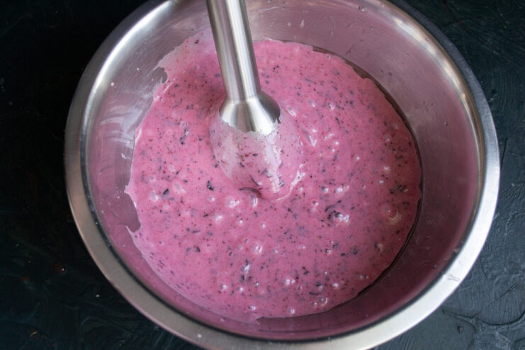Blending The Ingredients Blending berry mixture with an immersion blender into a smooth pink puree