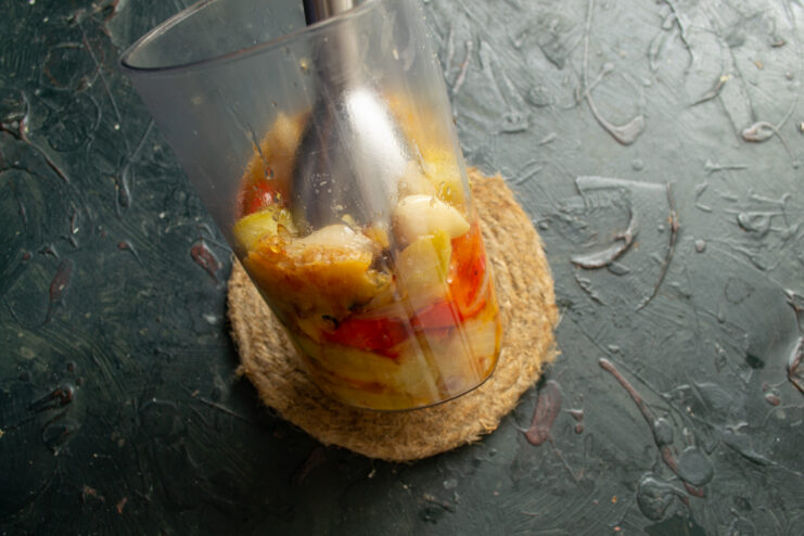 Blending the roasted vegetables Pureeing roasted vegetables with an immersion blender