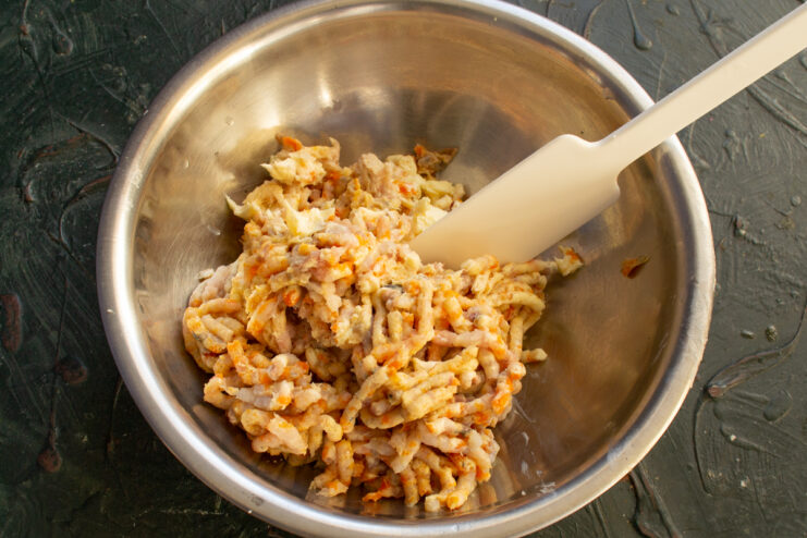 Grinding through a meat grinder Ground vorschmack mixture in a bowl with a spatula