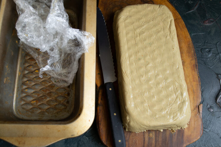 Unmolding the pâté Unmolded rectangular chicken liver pâté block resting on a wooden cutting board.