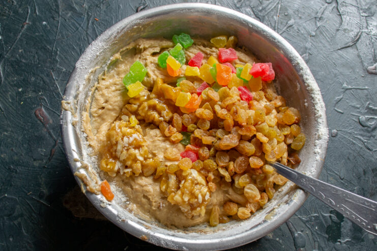 Raisins, candied fruit, and cashews sitting on top of the dough