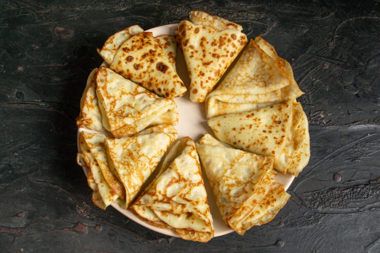 Zucchini crepes folded into triangles served on a platter