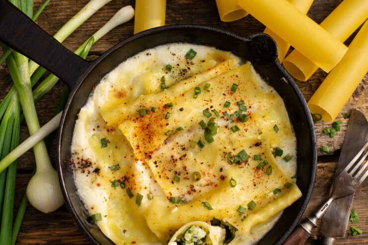 Baked cheese and scallion cannelloni in a creamy sauce garnished with paprika