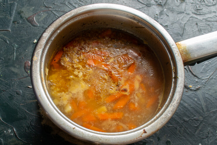 Simmering the Soup A covered saucepan simmering gently on a stovetop.